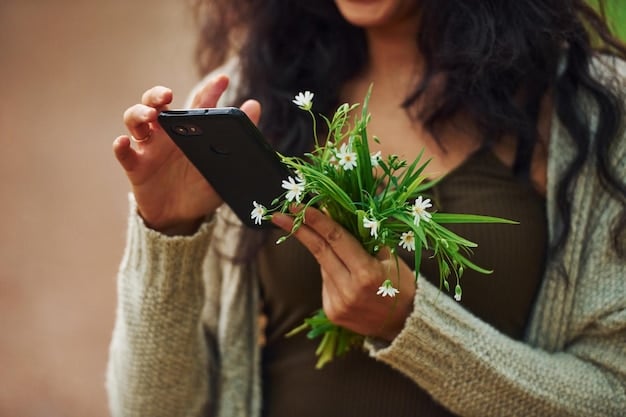 A person purposefully placing their phone in a drawer filled with natural items like flowers, rocks, and leaves, symbolizing a conscious choice to disconnect.
