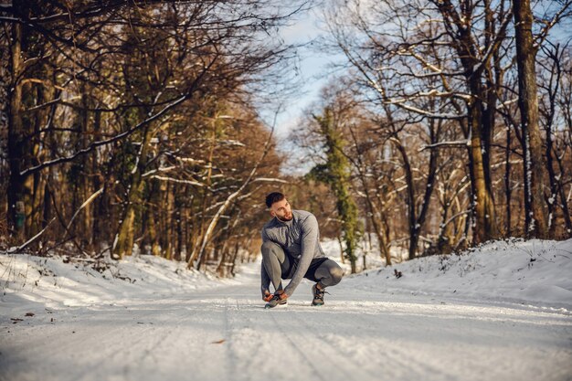 A person jogging outdoors in a winter setting, wearing appropriate warm clothing. The background shows a scenic, snowy landscape.