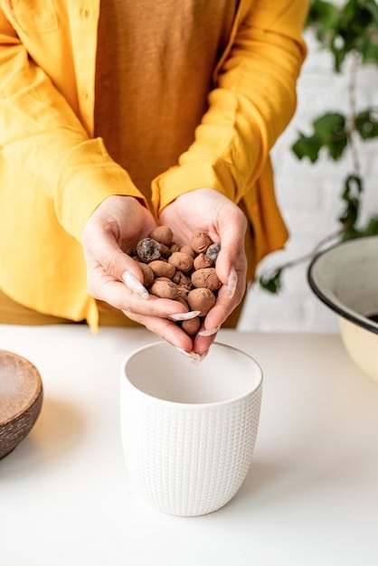 A close-up shot of a person's hand reaching for a handful of almonds from a bowl, with a blurred background showing an office setting.