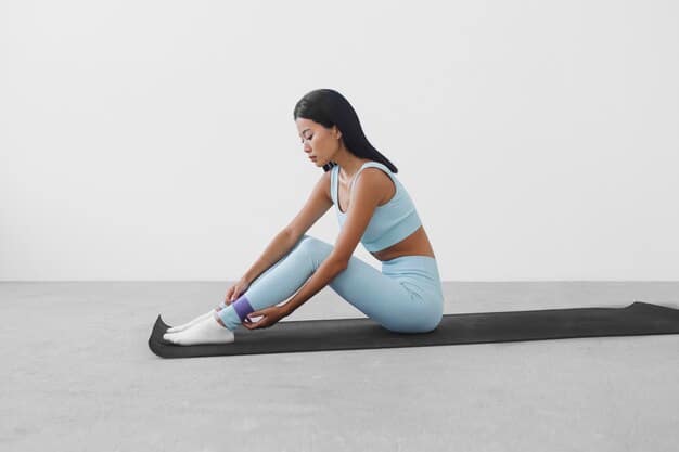 An individual is on the floor performing a seated hamstring stretch. One leg is extended straight out, while the other leg is bent with the foot tucked in towards the inner thigh of the extended leg. The person is gently reaching towards the toes of the extended leg, with a relaxed posture.