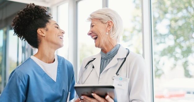 A doctor and patient smiling together during a check-up, indicating the positive impact of laughter on the patient's well-being.