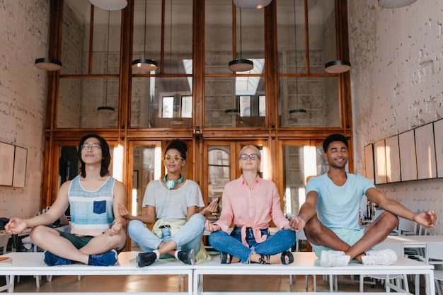 A diverse group of employees practicing yoga together in a brightly lit office space during a wellness program, symbolizing stress reduction through mindfulness.