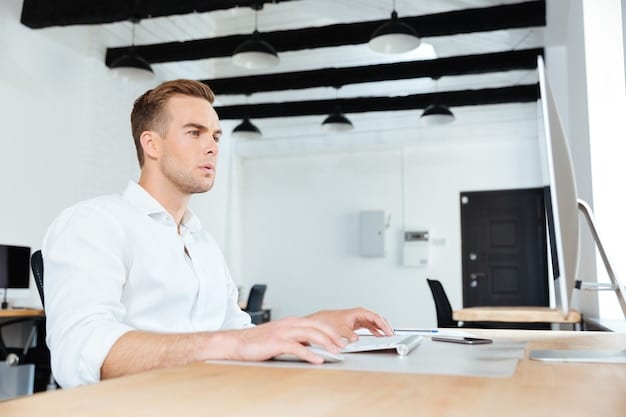 A focused professional at a clean desk in a well-lit office, working on a laptop with a determined expression. The scene conveys productivity and efficiency, emphasizing the connection between adequate sleep and improved work performance.
