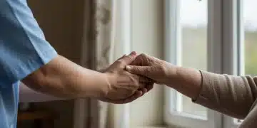Compassionate caregiver holding an elderly person's hand, looking out a window, representing support and the need for respite.