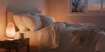 Serene bedroom with soft lighting, tea, and journal for mindful evening rituals